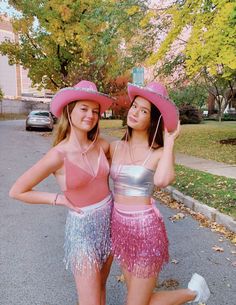 two young women wearing pink hats and fringe skirts