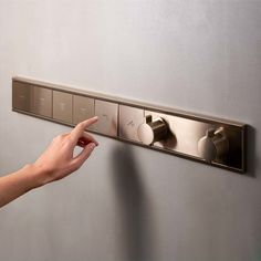 a person is pressing the button on a wall mounted light switch in an office building