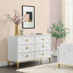 a bedroom scene with focus on the dresser and bed, which is decorated in pink and gold