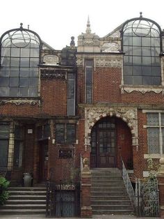 an old brick building with lots of windows on the front and back of it's facade