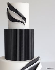 a three tiered cake with black and white designs