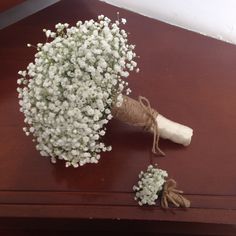 a bouquet of baby's breath sitting on top of a wooden table with twine