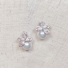 "Wedding Pearl Studs Earrings, Pearl Silver Wedding Earrings, Pearl Earrings Wedding, Silver Earrings for Wedding 💖 Our Current New Shop Promotion 💖 Get a free 2 pcs CZ Bobby Pin Set with every order! Order now and enjoy the added sparkle and elegance! (: Handcrafted with intricate detail, these dainty bridal earrings feature sparkling pave set of AAA-quality cubic zirconia that beautifully complement the lustrous simulated pearls. Whether you're a modern bride or a traditional one, these earrings are a versatile choice for your special day. 💖 Details - Post back closure - Measures 0.75\" long - AAA-grade cubic zirconia - Simulated pearl - Rhodium plating over brass - Tarnish resistance - Handcrafted from sustainable and recycled materials - Hypoallergenic, lead, and nickel free - Luxe Silver Bridal Accessories With Matching Earrings For Formal Occasions, Elegant Silver Clip-on Flower Earrings, Delicate Silver Pearl Earrings For Wedding, Delicate Silver Cluster Earrings For Wedding, Silver Flower Drop Earrings For Wedding, Delicate Silver Cluster Earrings For Formal Occasions, Elegant Silver Flower Earrings For Wedding, Elegant Silver Earrings For Wedding Gift, Elegant Silver Flower Wedding Earrings