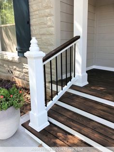 a porch with white railing and wood steps