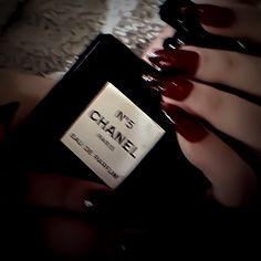 a woman's hands holding a bottle of chanel perfume