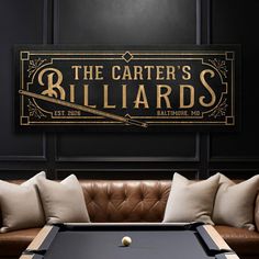 a pool table in front of a couch with pillows on it and a sign that says the center's billiards