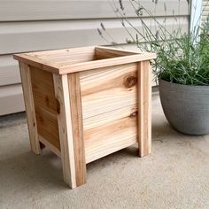 a small wooden box sitting next to a potted plant