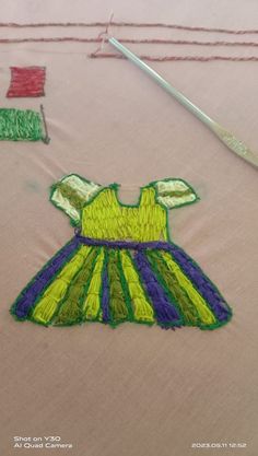 a close up of a dress on a table with some scissors and thread next to it