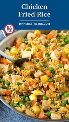 chicken fried rice with peas and carrots in a pan on a blue tablecloth