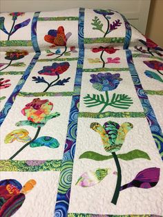 a quilted bedspread with flowers and leaves on it