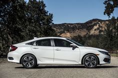 a white car parked in front of some trees