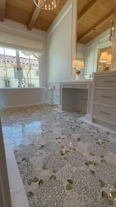 a large bathroom with white and green tiles on the floor