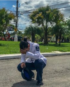 a man kneeling down to pick up something from the ground in front of his face