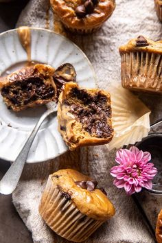 some muffins are sitting on plates next to a pink flower