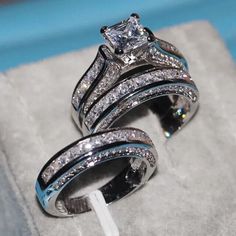 two wedding rings sitting on top of each other in a ring box with blue velvet