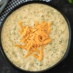 a black bowl filled with cheese on top of a table