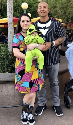 a man and woman standing next to each other holding a stuffed animal in their hands