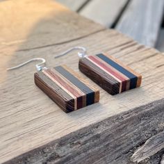 the wooden earrings are made from wood and have black, red, and blue stripes