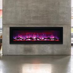 an electric fireplace with red and purple flames in a concrete walled room next to a large window