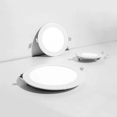 two round lights sitting on top of a white counter next to a bowl and plate