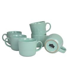 a set of four tea cups and saucers in mint green with gold rims