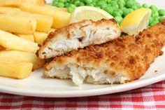 a white plate topped with cut in half chicken and french fries