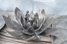 a metal flower sitting on top of a wooden table