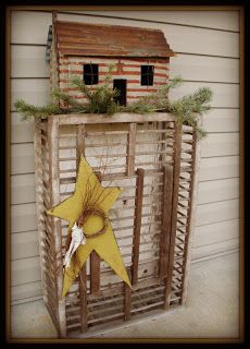 a birdhouse made out of wooden slats on the side of a building with a star decoration