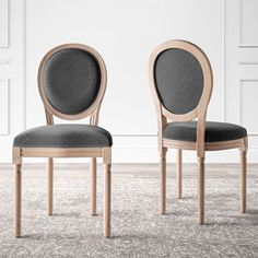 two chairs sitting next to each other on top of a carpeted floor in front of a white wall