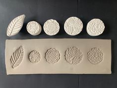 five white clay molds sitting on top of a black table next to each other