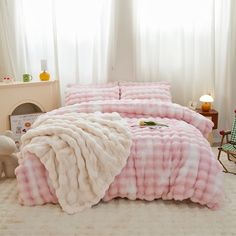 a bed covered in pink and white checkered blankets