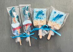 three toothbrushes wrapped in plastic and tied with blue ribbon are sitting on a table