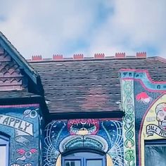 a colorful building with a clock on it's side and windows painted in different colors