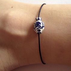 a woman's arm with a blue and white bracelet on it