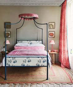 a bedroom with a canopy bed and pink curtains