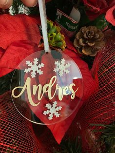 an ornament hanging from a christmas tree with snowflakes and pine cones