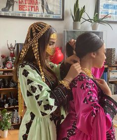 two women standing next to each other in front of a mirror