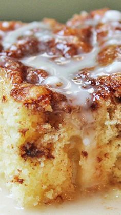 a close up of a piece of cake on a plate with icing and cinnamon