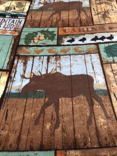 an animal rug is on the floor in front of a wooden fence with moose silhouettes