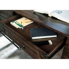 a desk with a book, notebook and pen on it