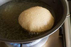 a ball of bread is being cooked in a skillet on the stove burner