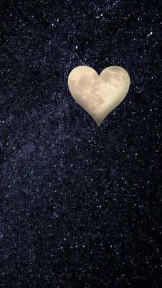 a white heart shaped object floating in the air over a night sky filled with stars