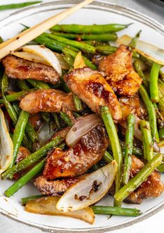 chicken and green beans with chopsticks on a plate