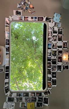 a mirror that has pictures on it with trees in the background and lights hanging above