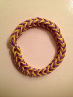 a purple and yellow braided bracelet sitting on top of a table