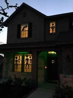 the silhouettes of people are projected in the windows of this house