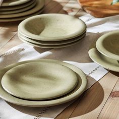 a table topped with plates and bowls on top of a wooden table