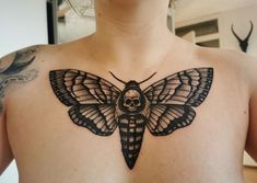 a black and white moth tattoo on the chest