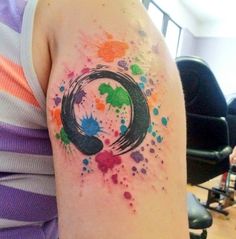 a woman's arm with colorful ink splattered on it and the letter o