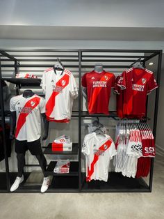 a display case filled with red and white soccer jerseys